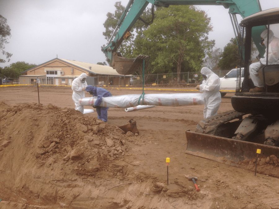 Kwik Lift crew in protective coveralls removing asbestos pipe lagging