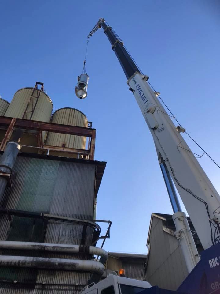 Crane lowering a large steel vessel into position on a Bundaberg worksite